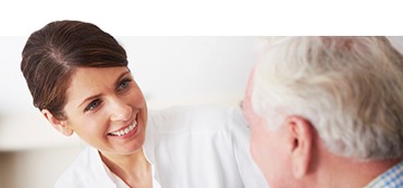 A woman smiling at an older gentleman