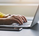 Women's hands typing on laptop keyboard