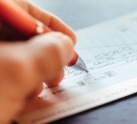 Woman writing out check for donation