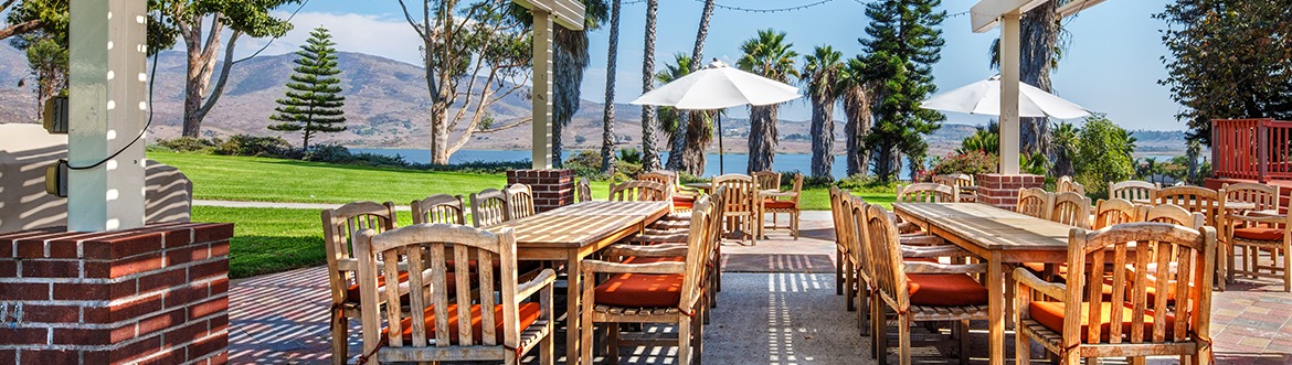 Outdoor patio with tables and chairs overlooking the hills