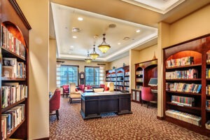 Library with multiple shelves of books on the walls and a desk in the center of the room