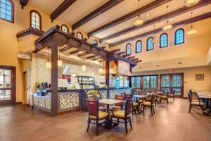 Indoor dining area with multiple tables and food counter with "Sweetwater Grill" sign above it