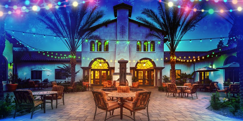 Outdoor seating area in courtyard with multicolored lights hanging